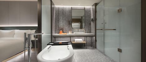 A modern bathroom with a freestanding bathtub, a large mirror, and a glass shower enclosure.