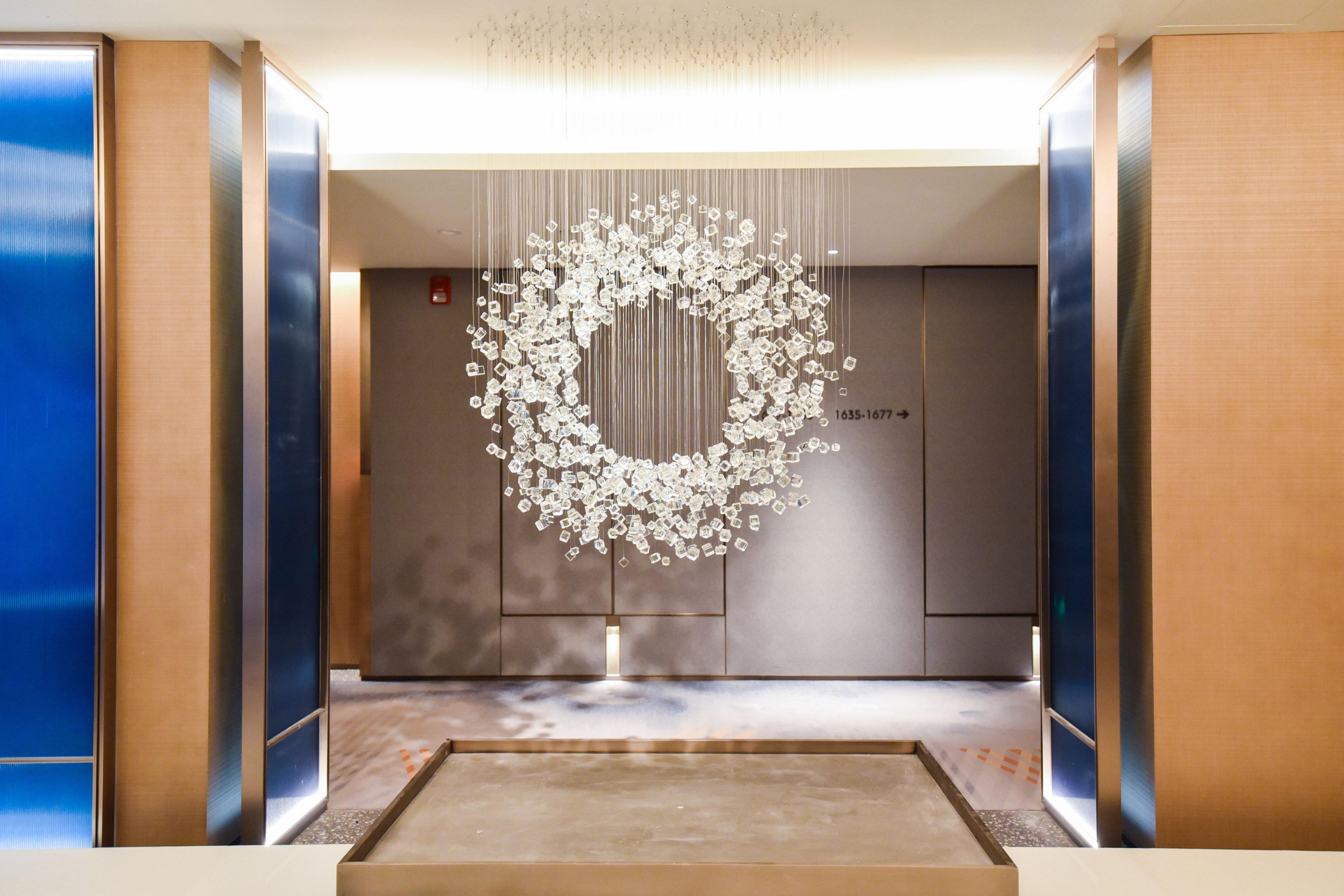 An elevator with a modern design, featuring a unique hanging light fixture and a digital display with floor numbers.