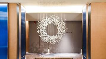 An elevator with a modern design, featuring a unique hanging light fixture and a digital display with floor numbers.