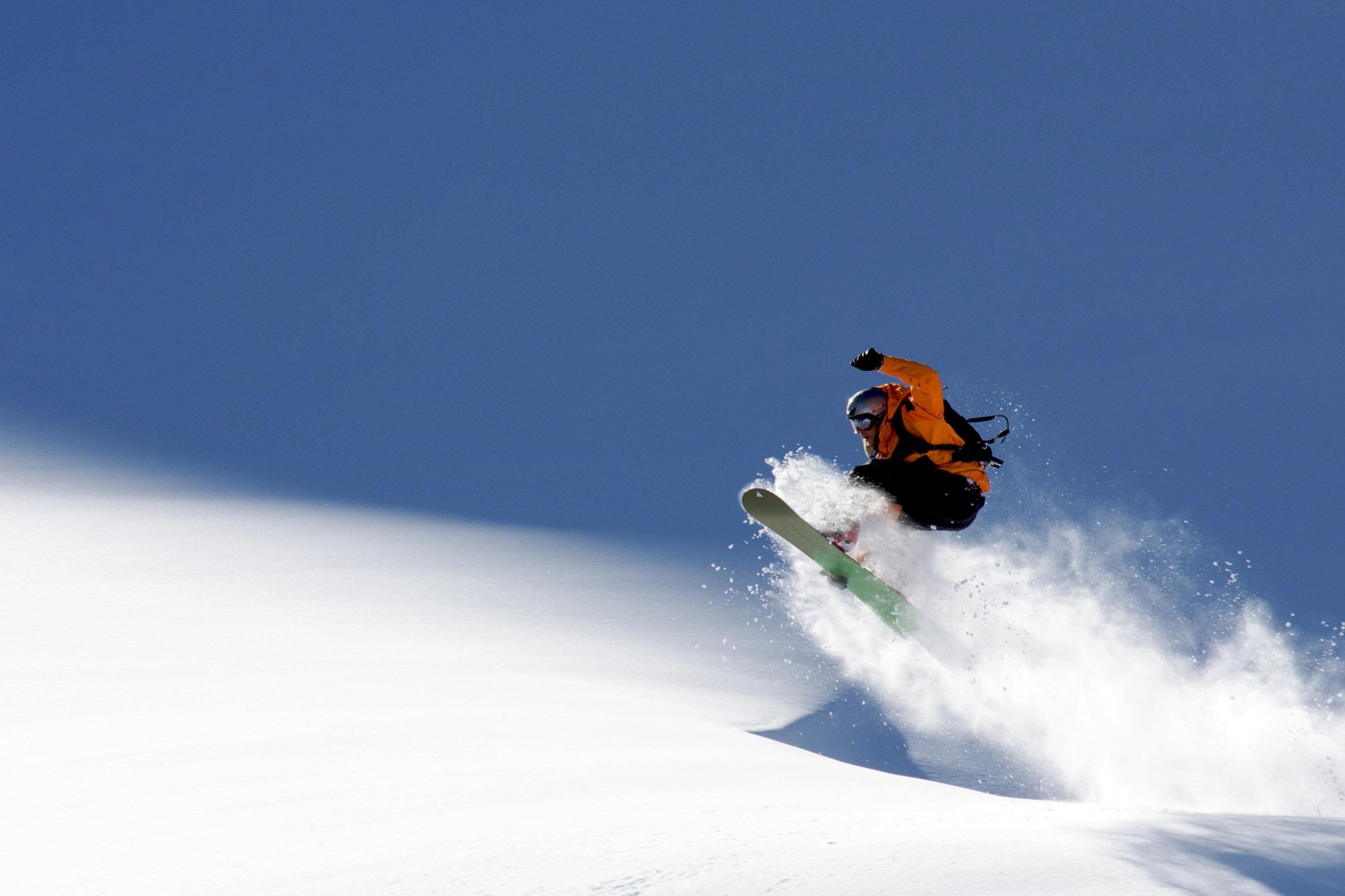 A snowboarder in mid-air performing a jump on a snowy slope.