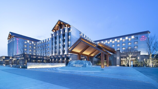 A modern hotel with a prominent entrance, multiple floors, and a large sign displaying the name 'Crowne Plaza'. - Crowne Plaza Beijing Badaling (Yanqing)