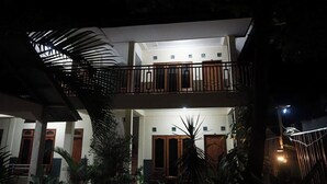 A two-story building with a balcony, wooden doors, and a staircase. - Sagita Bungalow by Zuzu (Gili Trawangan)