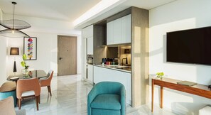 A modern kitchen with a built-in oven, a coffee machine, and a large flat-screen TV mounted on the wall. - Th8 Palm Dubai Beach Resort Vignette Collection (Dubai)