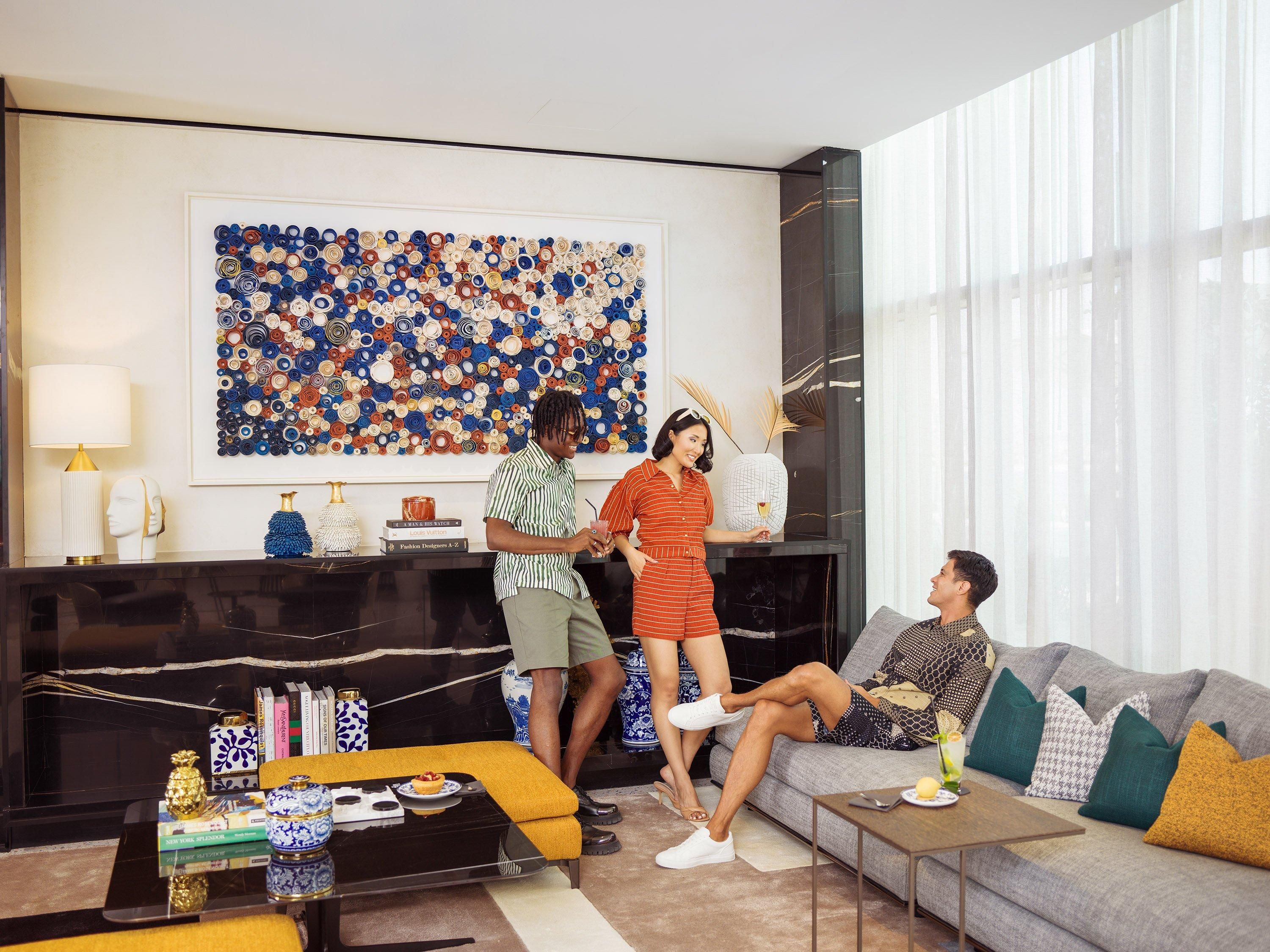 A modern living room with a black fireplace, a large abstract art piece, and a sofa with cushions.