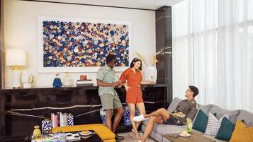 A modern living room with a black fireplace, a large abstract art piece, and a sofa with cushions.