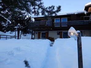 A two-story building with a wooden balcony and a snow-covered landscape. - Casa Mulinatsch, (Rueras Sedrun), 670.01/02 by Interhome (Rueras Dieni)
