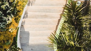 A staircase surrounded by lush greenery, leading to a building with a light-colored exterior. - Lifestyle Hotel Juquilita - La Punta (Santa María Colotepec)