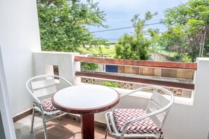 A balcony with a table and chairs, a view of the sea, and a wooden fence. - Lifestyle Hotel Juquilita - La Punta (Santa María Colotepec)