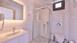 A modern bathroom with a glass-enclosed shower, a white sink, and a toilet. - Lobelya Suites (Kaş)