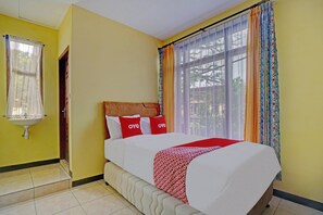 A hotel room with a bed, a window with curtains, a sink, and a door. - OYO 90488 Harwin Homestay (Batu)