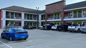 A multi-story motel with a parking lot. - Scottish Inns & Suites Kingwood (Kingwood)
