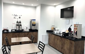 Ein Café mit Fernseher, Sitzgelegenheiten und Kaffeemaschinen.