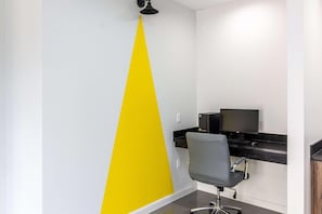 Un espace de bureau moderne comprenant un bureau, une chaise et un écran d’ordinateur.