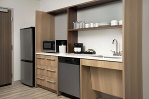 Una cocina moderna con lavavajillas integrado, cafetera y lavamanos.