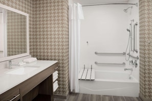 A bathroom with a white sink, mirror, towel rack, and a shower with grab bars. - Home2suites by Hilton Miami Airport S. Blue Lagoon (Miami)
