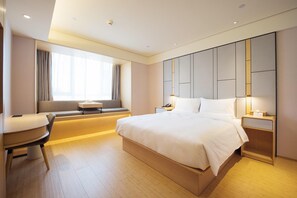 A modern hotel room with a large bed, a seating area with a table, and a large window. - Ji Hotel (Jilin)