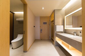 A modern bathroom with a toilet, a sink, and a mirror. - Ji Hotel (Hefei)
