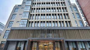 Um hotel moderno com fachada imponente, grandes janelas e design vertical.