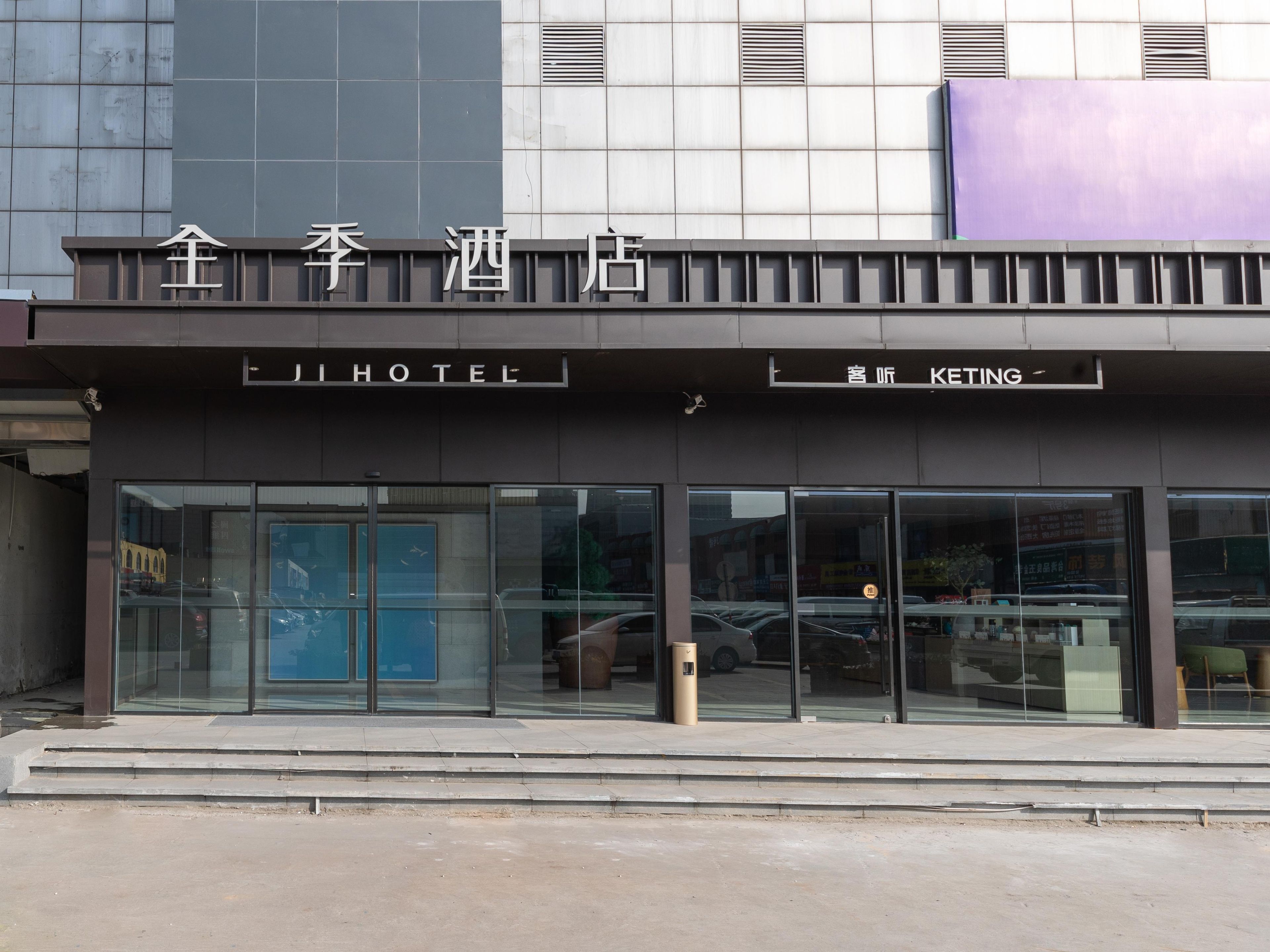 A hotel entrance with a sign reading 'JI HOTEL' and another sign for 'KETING.'