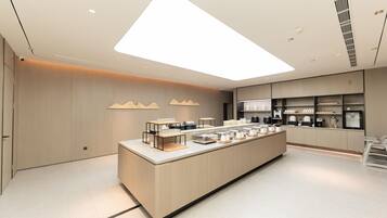 Una cocina moderna con una isla central, electrodomésticos integrados y un diseño limpio y minimalista.