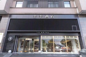 A hotel entrance with a modern facade, large glass windows, and a sign indicating the name 'JI HOTEL'. - Ji Hotel (hangzhou South Railway Station, Xiaoshao (Hangzhou)