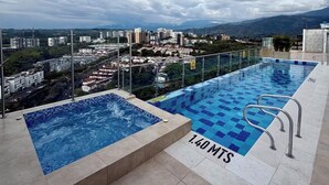 En pool på taket med utsikt över stadsbilden och bergen.