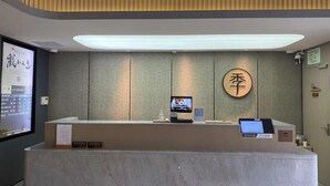 A hotel reception desk with a digital screen, a wooden sign with Chinese characters, and a reception counter.