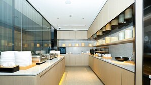 Una cocina moderna con electrodomésticos de acero inoxidable, una isla central y un panel de vidrio.