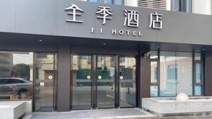 A hotel entrance with a modern design, featuring glass doors and a sign in both Chinese and English.