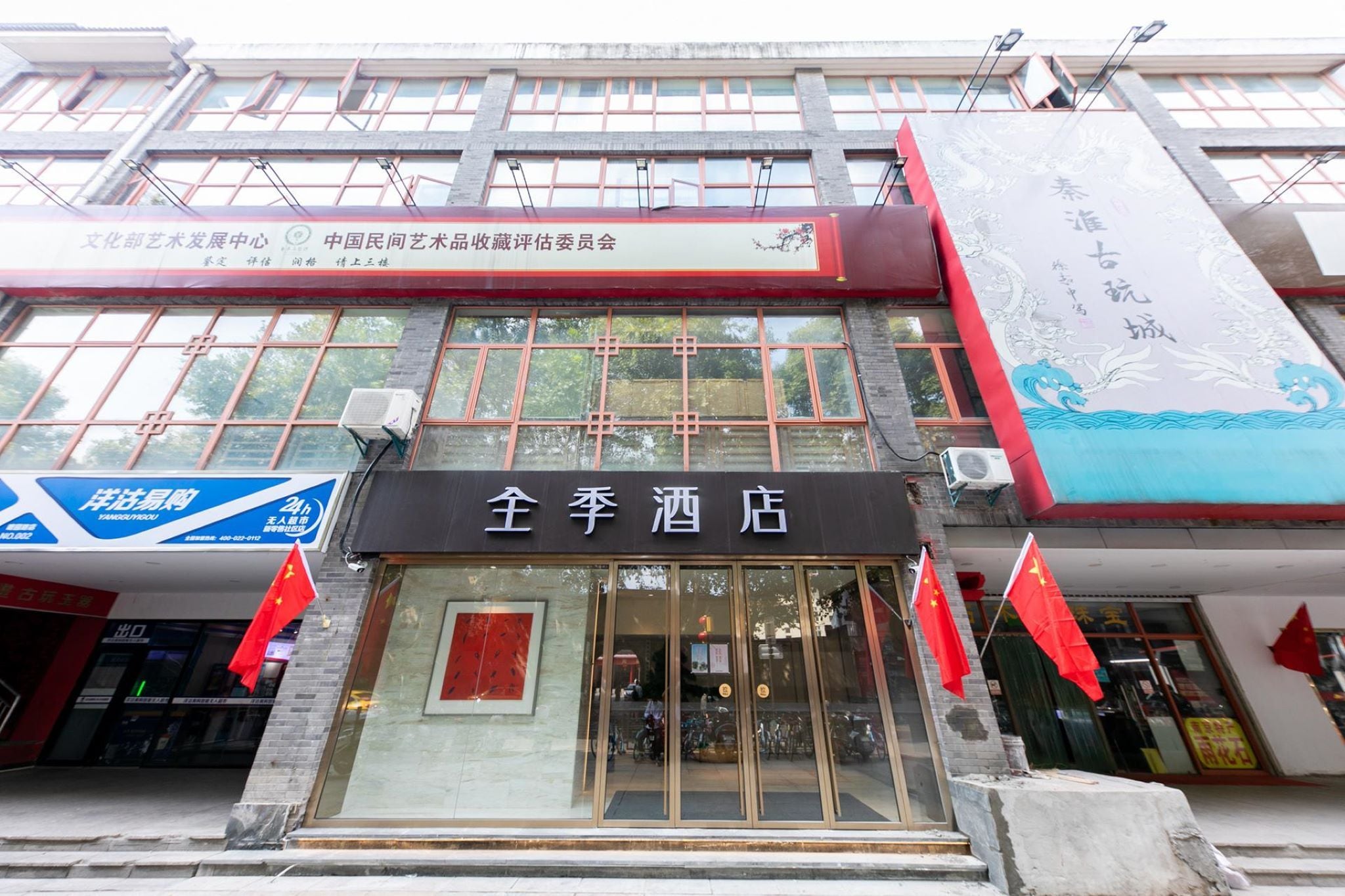 A hotel with a traditional Chinese architectural style, featuring large windows and a prominent entrance.