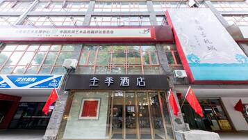 A hotel with a traditional Chinese architectural style, featuring large windows and a prominent entrance.