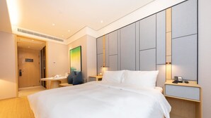 A hotel room with a large bed, bedside tables, a desk, and a painting on the wall. - Ji Hotel (nanjing Confucius Temple Pedestrian Stre (Nanjing)