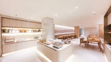Un hall d’hôtel moderne avec un îlot central, des sièges en bois et un mur décoratif en marbre.
