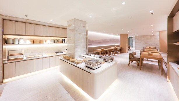 A modern hotel lobby with a central island, wooden seating, and a marble accent wall. - Ji Hotel (nanjing Confucius Temple Pedestrian Stre (Nanjing)