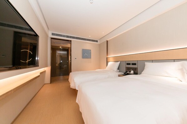 A hotel room with two beds, a bedside table with a phone and a cup, a window with blinds, and a door leading to a hallway. - Ji Hotel (hefei South Railway Station North Square (Hefei)