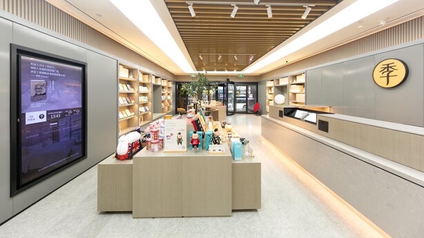 A modern interior with a reception desk, bookshelves, and a digital display. - Ji Hotel (Nanjing)