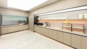 A modern kitchen with a glass partition, stainless steel appliances, and a breakfast bar. - Ji Hotel (Nanjing)