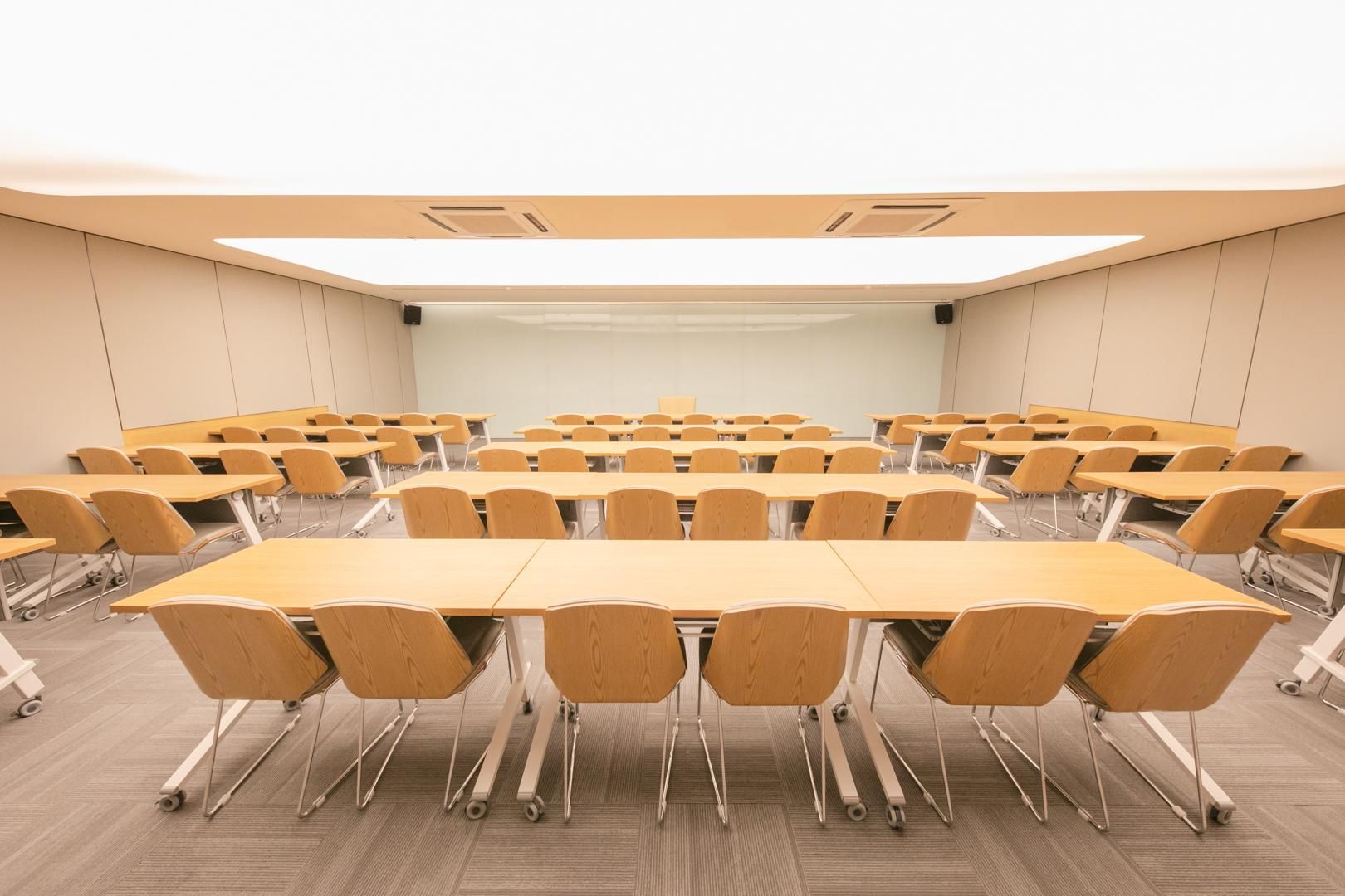 A conference room with a large table, chairs, and a projector screen.
