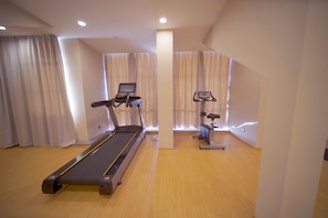 A gym with a treadmill, elliptical, and stationary bike, wooden flooring, and large windows with curtains. - Ji Hotel (renmin University Of China Metro Station (Beijing)
