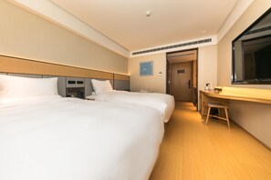 Hotellihuone, jossa on kaksi sänkyä, työpöytä ja peili.
