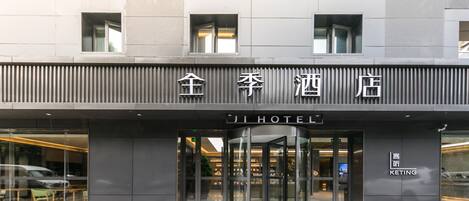 A hotel entrance with a revolving door, a sign with Chinese characters, and a 'KETING' logo.