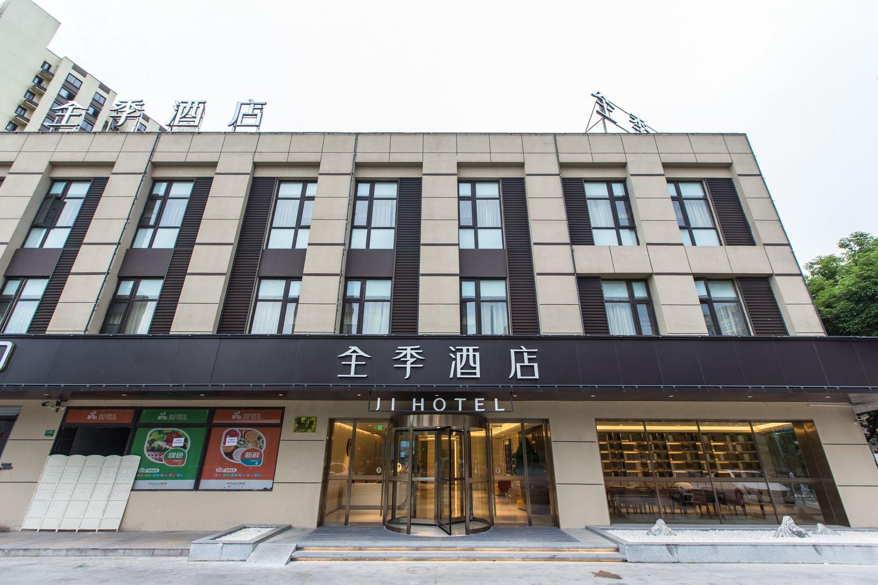 A hotel with a modern facade, large windows, and a revolving door entrance.
