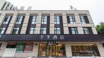 A hotel with a modern facade, large windows, and a revolving door entrance.