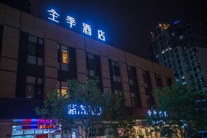 A hotel building with illuminated signage at night. - Ji Hotel (Shanghai)