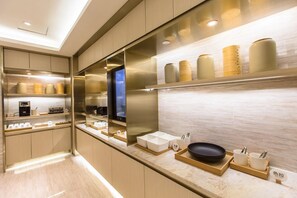A modern kitchen with built-in appliances, a large mirror, and a countertop with various kitchenware. - Ji Hotel (Shanghai)