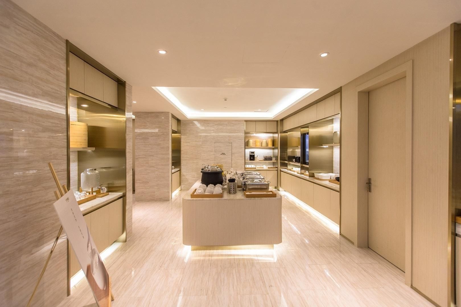 Un moderno vestíbulo de hotel con un mostrador de recepción central, un espejo grande y un diseño minimalista.