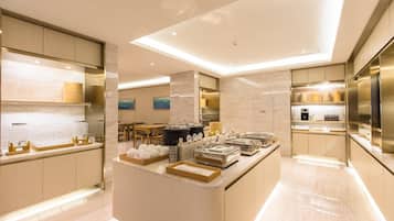 Een moderne keuken met een centraal eiland, houten kasten en een eethoek op de achtergrond.