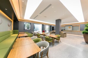 A modern hotel lobby with green seating, wooden tables, and a reception desk. - Ji Hotel (xi'an Jinye Road, Shenzhou Digital Techn (Xi'an)