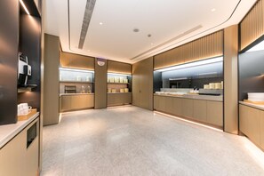 A modern kitchen with built-in appliances, wooden paneling, and a clean, minimalist design. - Ji Hotel (xi'an Jinye Road, Shenzhou Digital Techn (Xi'an)