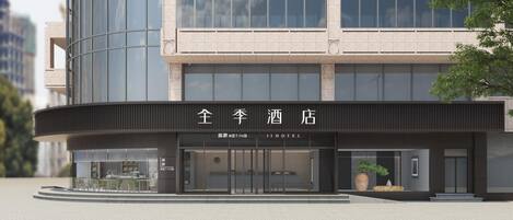 A modern hotel with a curved facade, large windows, and a prominent entrance.